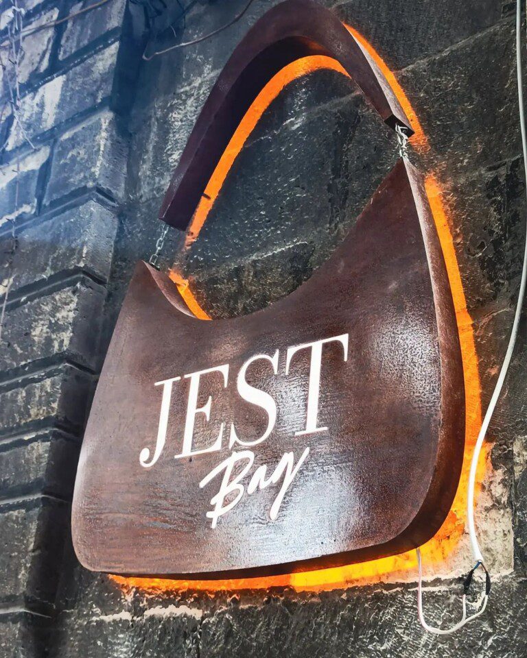 Backlit wooden signage on a stone wall