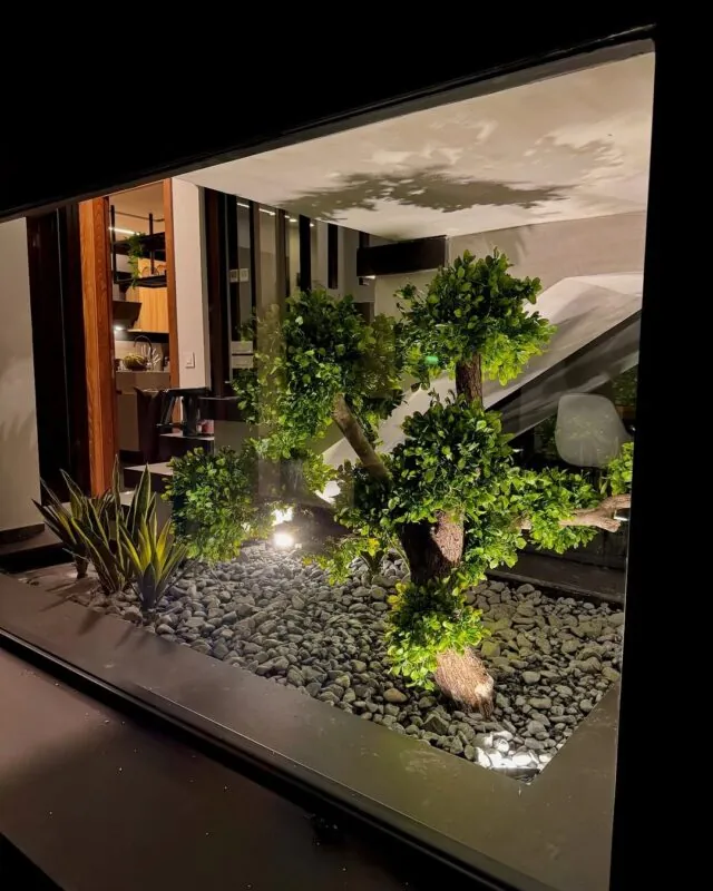 bonsai in a lit pebble garden — home under a staircase, Lebanon — installation by Neon Jungle Studios