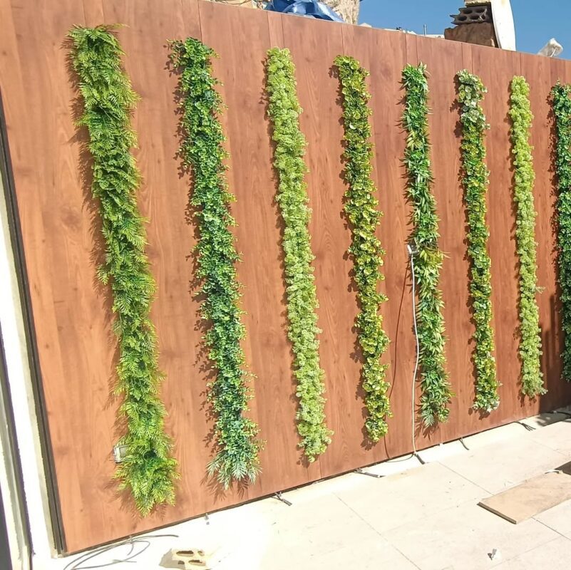 greenery strips on a wood slat wall — residential garden, Lebanon — installation by Neon Jungle Studios