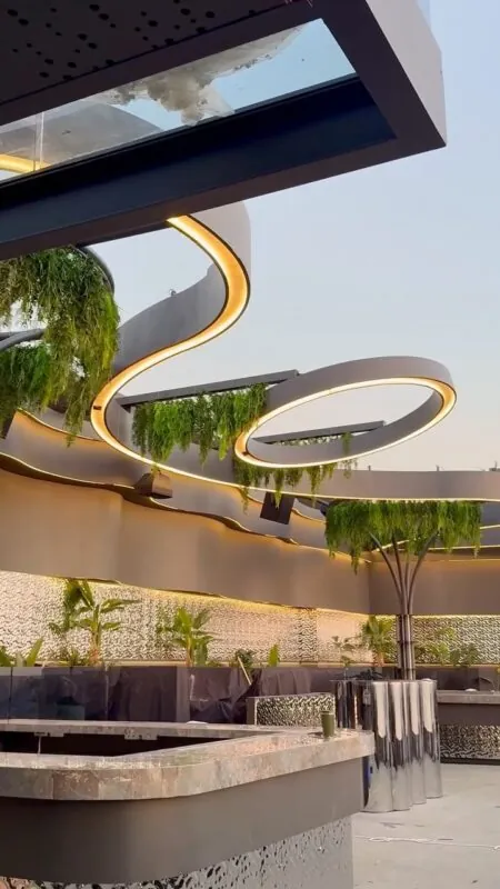 hanging greenery around a curved lit canopy — rooftop bar, Lebanon — installation by Neon Jungle Studios