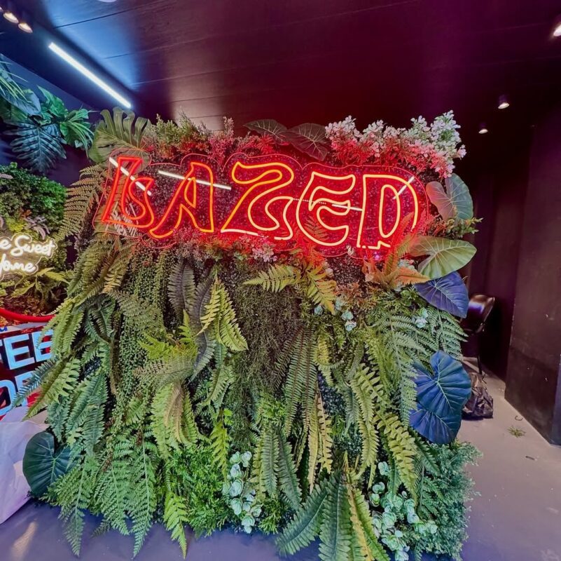 red neon name on a wall of ferns — venue wall, Lebanon — installation by Neon Jungle Studios