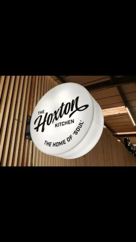 round white light sign — wood-clad facade, Lebanon — installation by Neon Jungle Studios