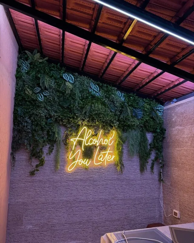 warm neon phrase under hanging greenery — terrace, Lebanon — installation by Neon Jungle Studios