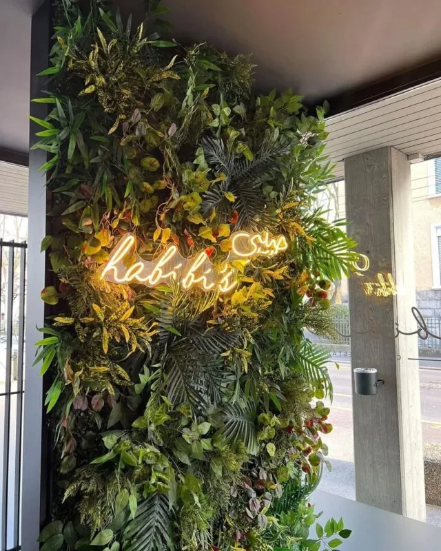 warm neon word on a green wall — photo spot wall, Lebanon — installation by Neon Jungle Studios